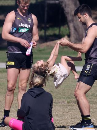 Trent Cotchin with his oldest daughter Harper as wife Brooke looks on at training in the hub. Pic: Michael Klein